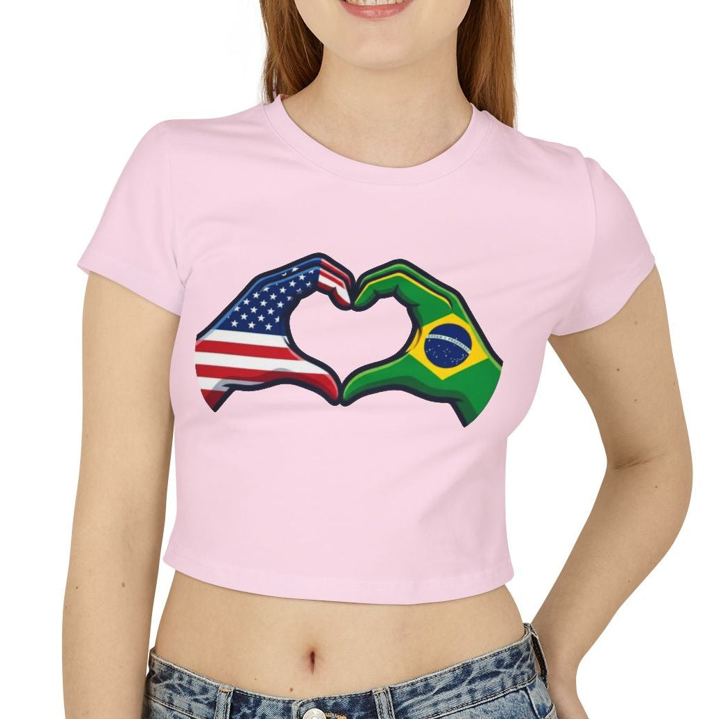 Person wearing a pink t-shirt with a heart design made of American and Brazilian flags, standing against a white background.