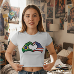 Woman wearing a t-shirt with a heart design incorporating Brazilian and American flags in a room with posters on the wall.