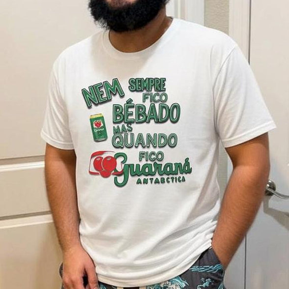 Person wearing a white t-shirt with green and red text and graphics, standing in a room.