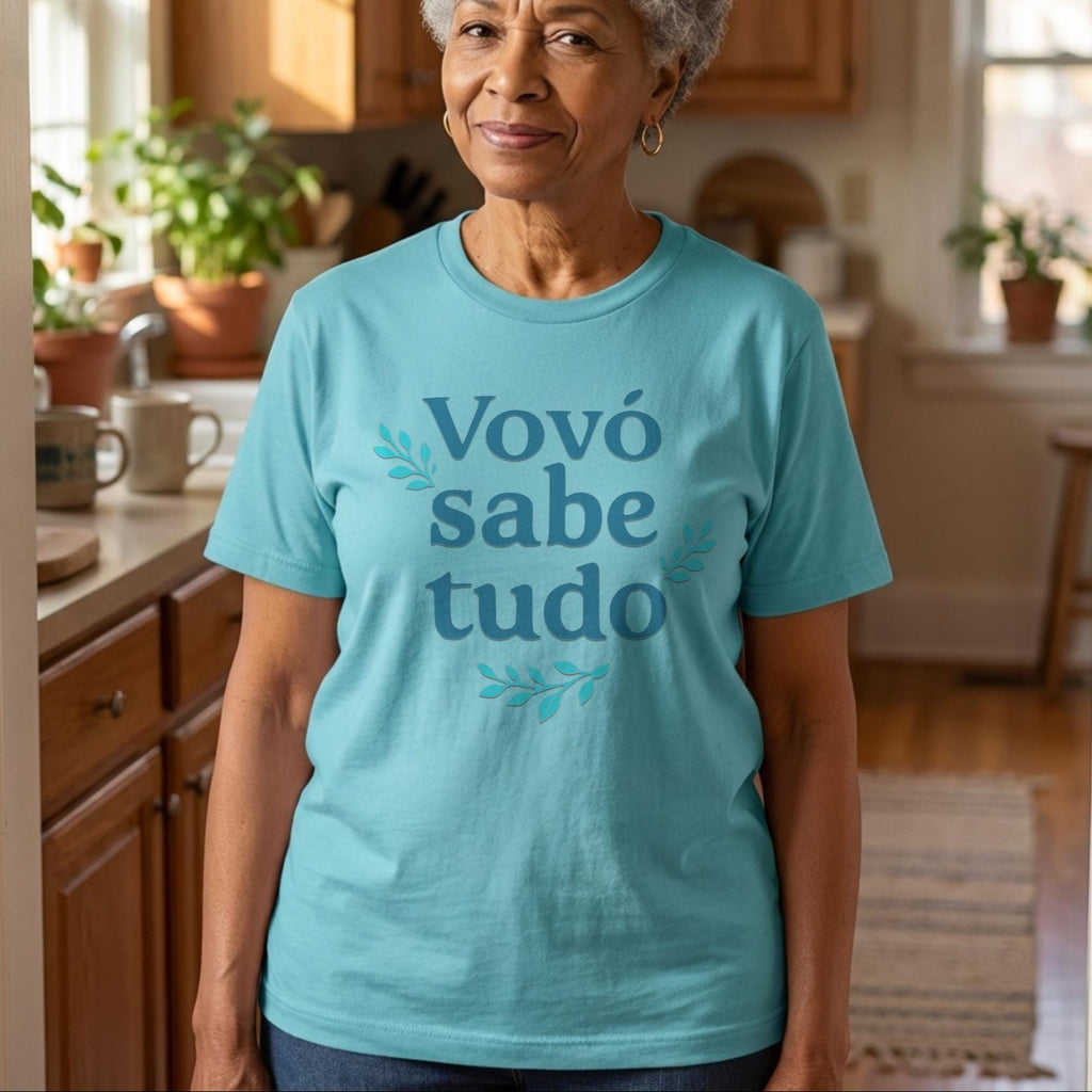 Woman wearing a turquoise t-shirt with 'Vovó sabe tudo' text in a kitchen.