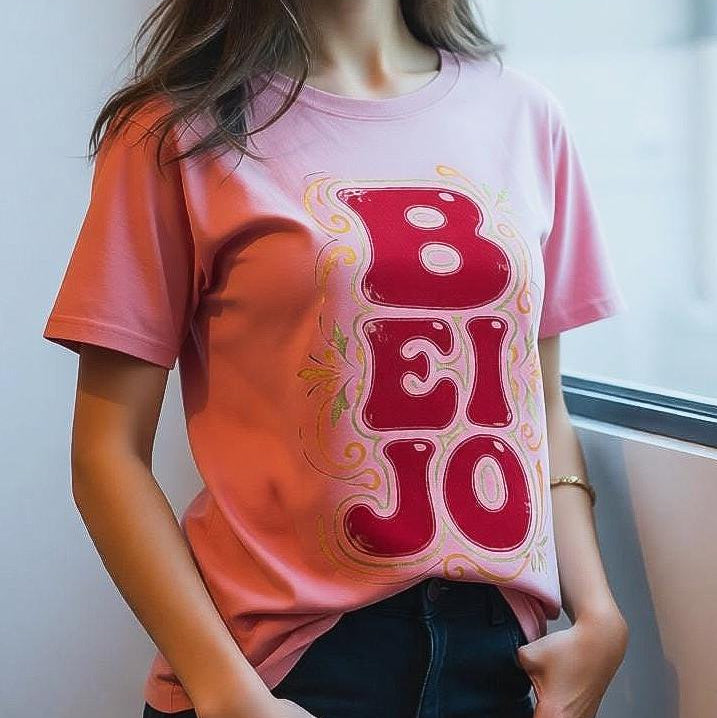 Person wearing a pink t-shirt with a red graphic design